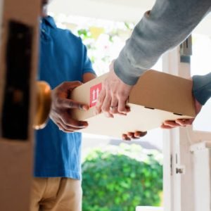 Hands, box and delivery man at front door in home with client, services and shipping for commercial product. People, courier and cardboard package for supply chain, logistics or distribution at house